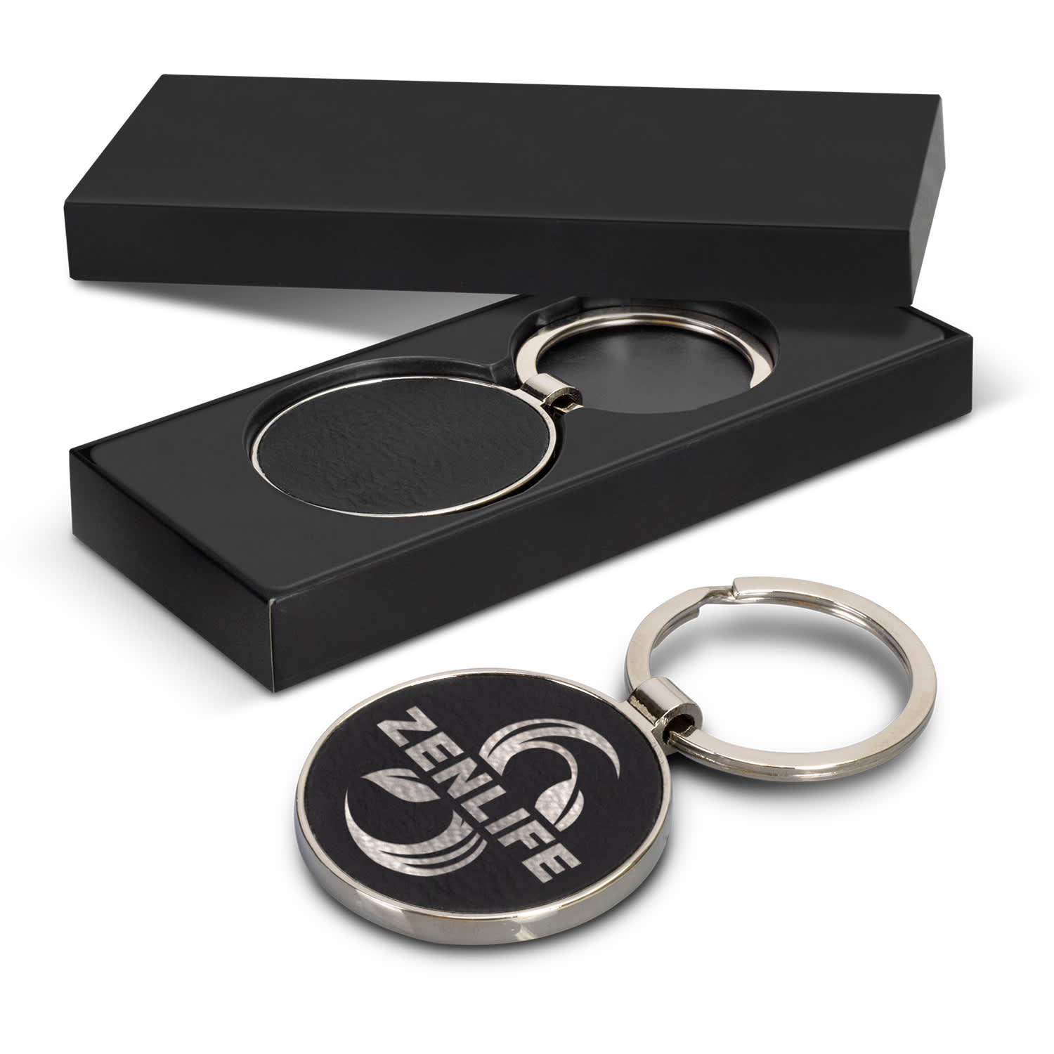 A round silver key ring with a black, textured surface, presented in a sleek black box. Capulet Key Ring - Round - Image 1