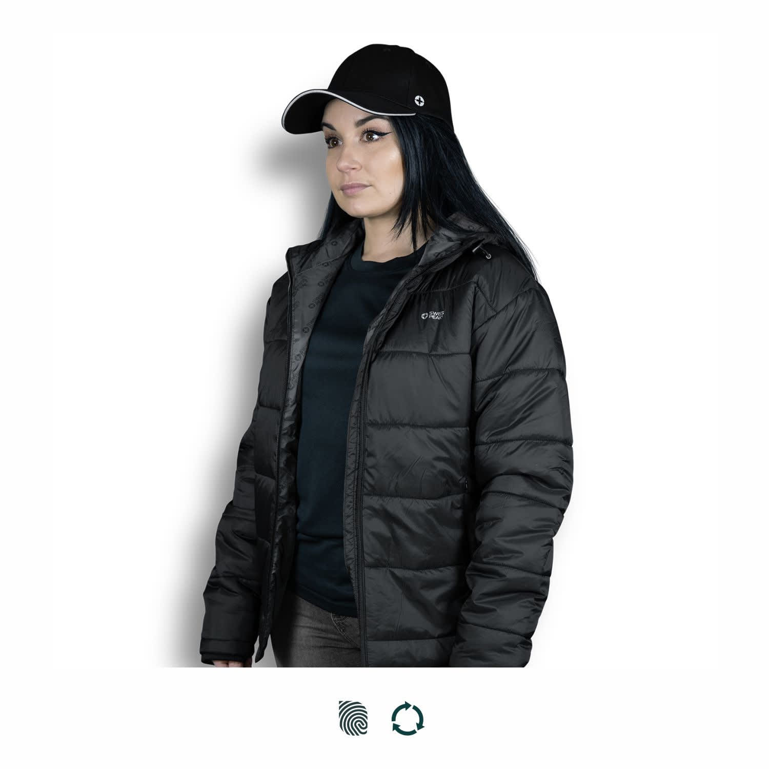 A black Swiss Peak Urban Puffer Jacket worn by a woman, paired with a black cap. The jacket features a logo. Swiss Peak Urban Puffer Jacket - Image 1