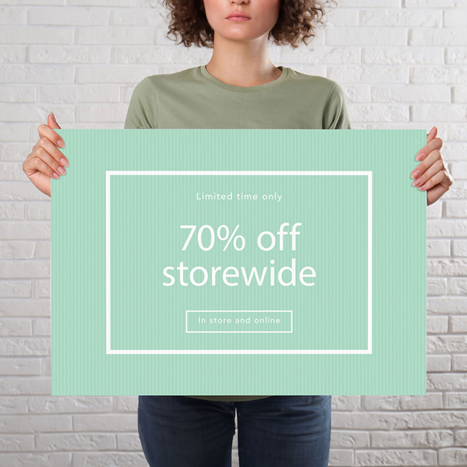 A person holds a large green sign with a white border, featuring a promotional message about storewide discounts. 600 W x 450 H Core Flute - Image 1