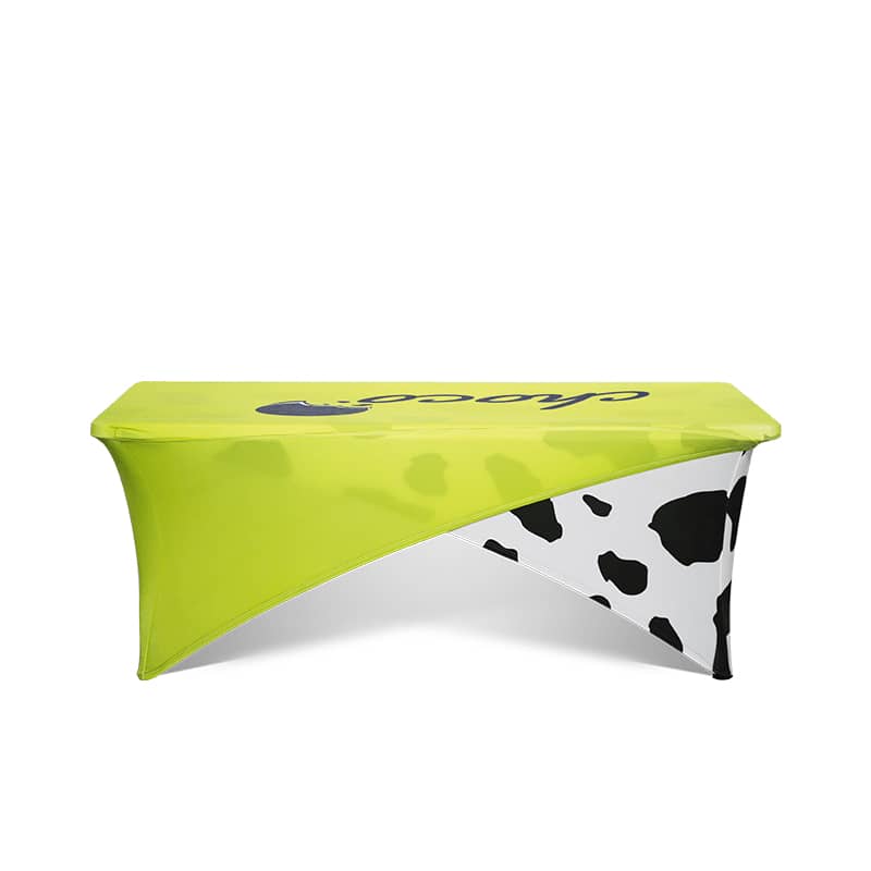 A bright lime green and black cow-patterned stretch tablecloth designed for an 8ft table, featuring a branding logo. Cross-over Stretch Table Cloth * 8ft - Image 1