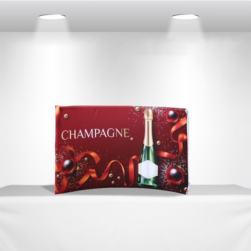 A vibrant red tabletop tension fabric display featuring a champagne bottle and decorative elements. It includes a logo. Tabletop Tension Fabric Display - Image 1