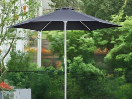 A black café umbrella with a sturdy white pole, set against a lush green garden backdrop. Café Umbrella No Valance 3m x 3m - Image 1