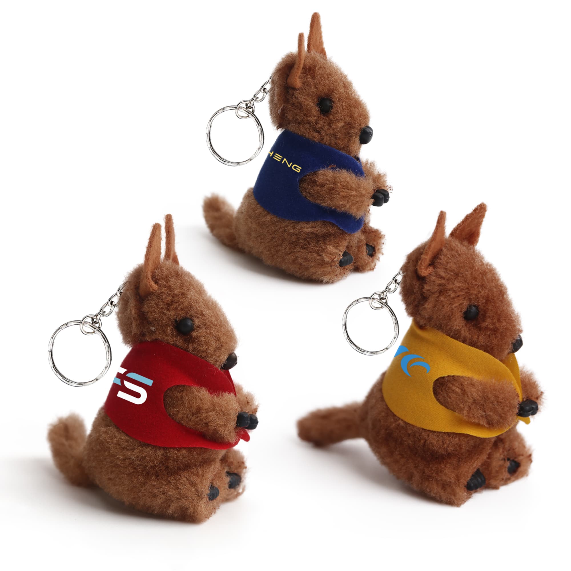 Three kangaroo-shaped plush toys with keychains, featuring brown fur and colourful vests in red, blue, and yellow. Kangaroo Clip on Stuffed Plush Toy - Image 1