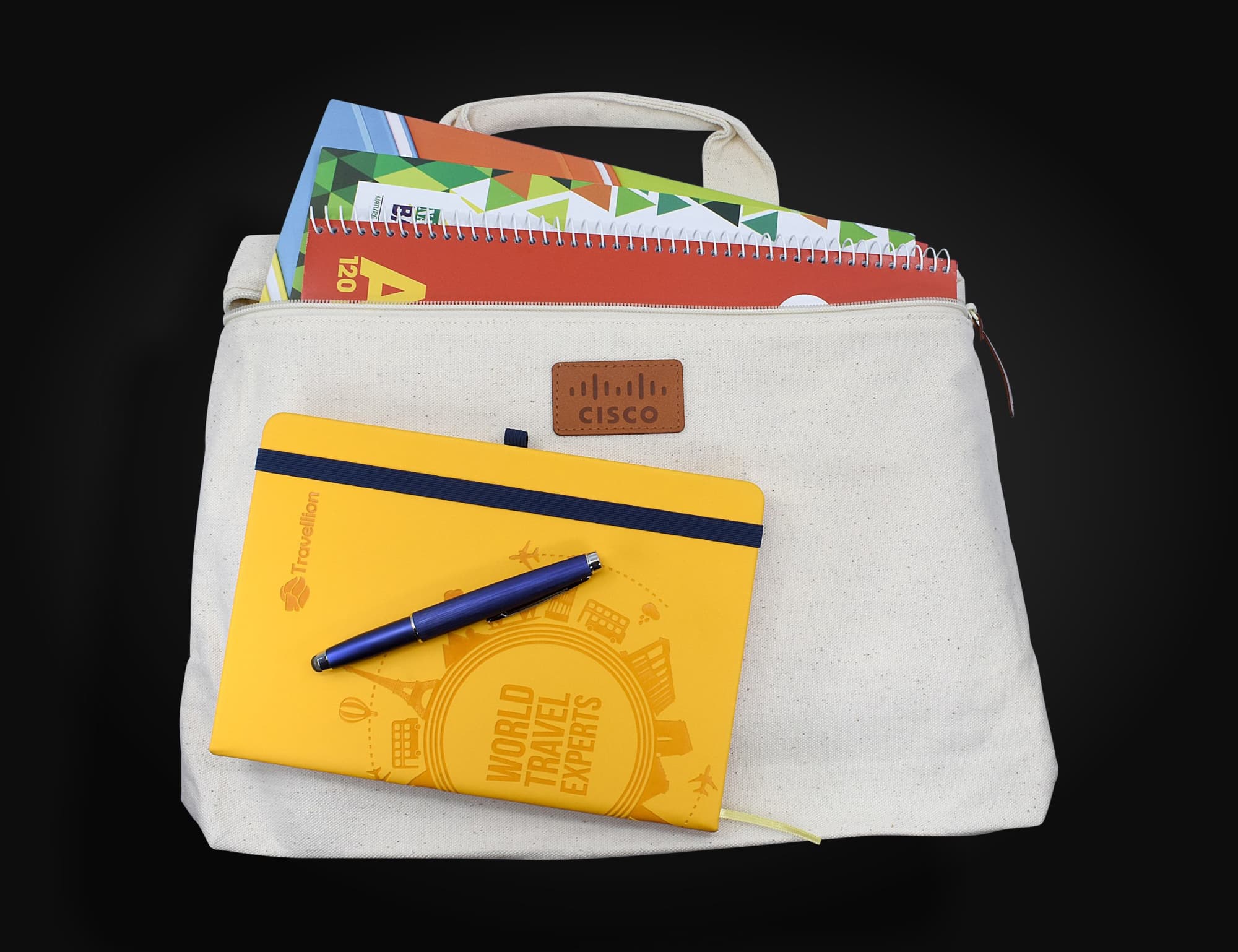 A cream-coloured conference bag with a handle, containing notebooks and a blue pen, featuring a logo. Calico Conference Bag 28cm x 37cm x 6cm - Image 1