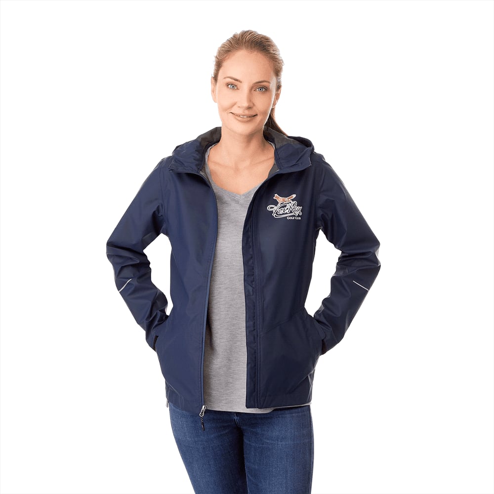 A women's rain jacket in navy blue with a hood and a logo on the chest, paired with a grey top and denim jeans. Cascade Jacket - Womens - Image 1