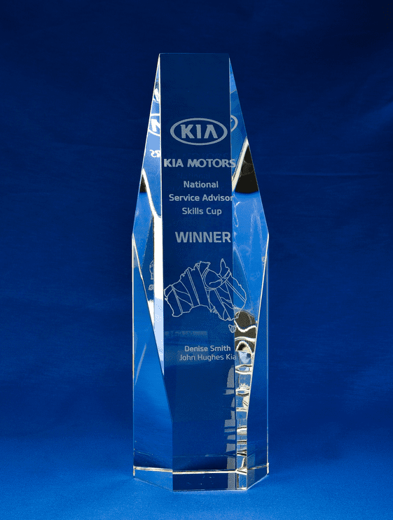 A clear, tall crystal award with a hexagonal shape, featuring engraving and a logo at the top. Sliced Crystal Hexagon - Medium + Gift Box - Image 1