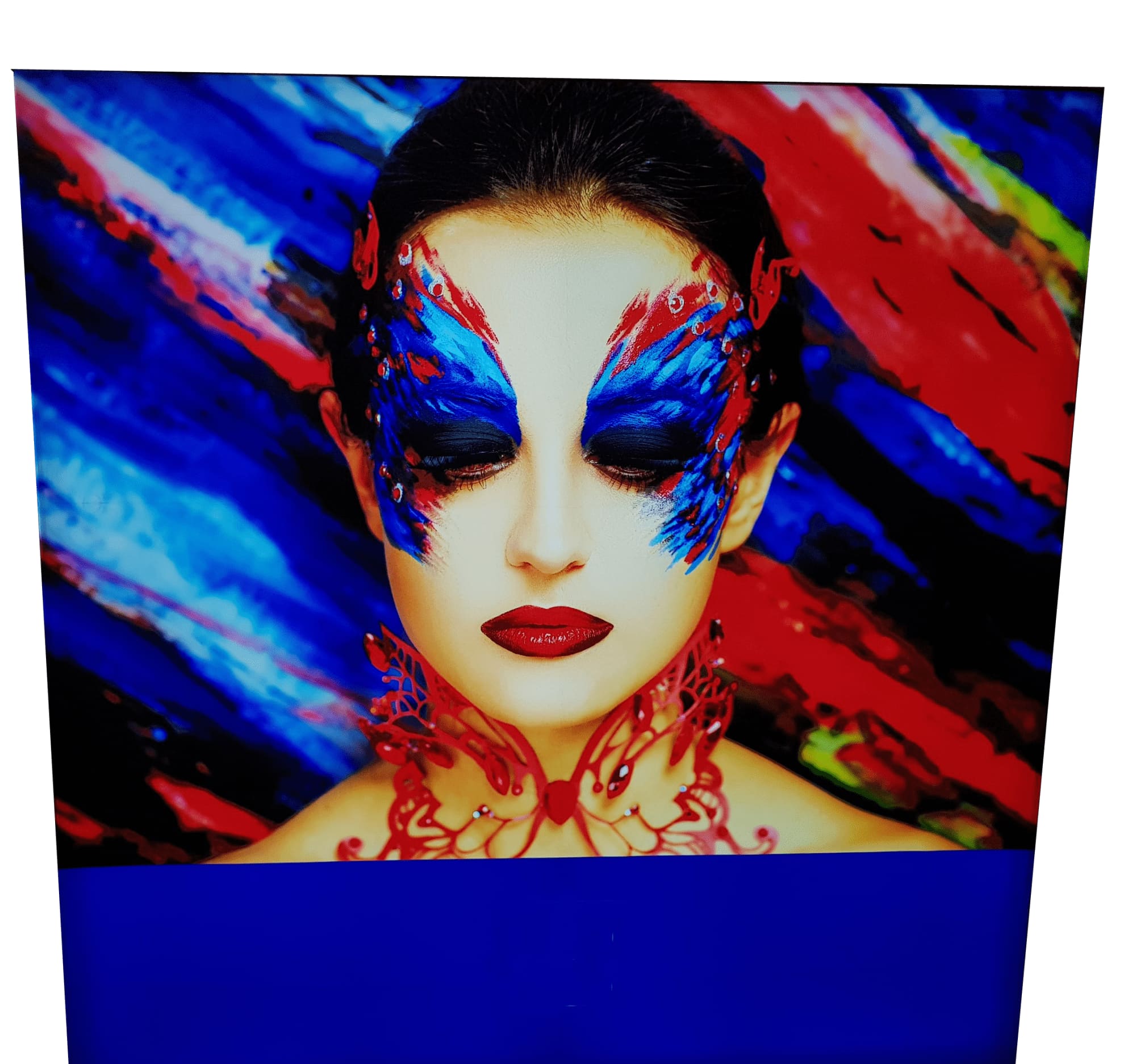 A decorative light box featuring a woman with vibrant blue and red face paint against a colourful, abstract background. Light Boxes -Light Box 24800mm x 1984mm - Image 1