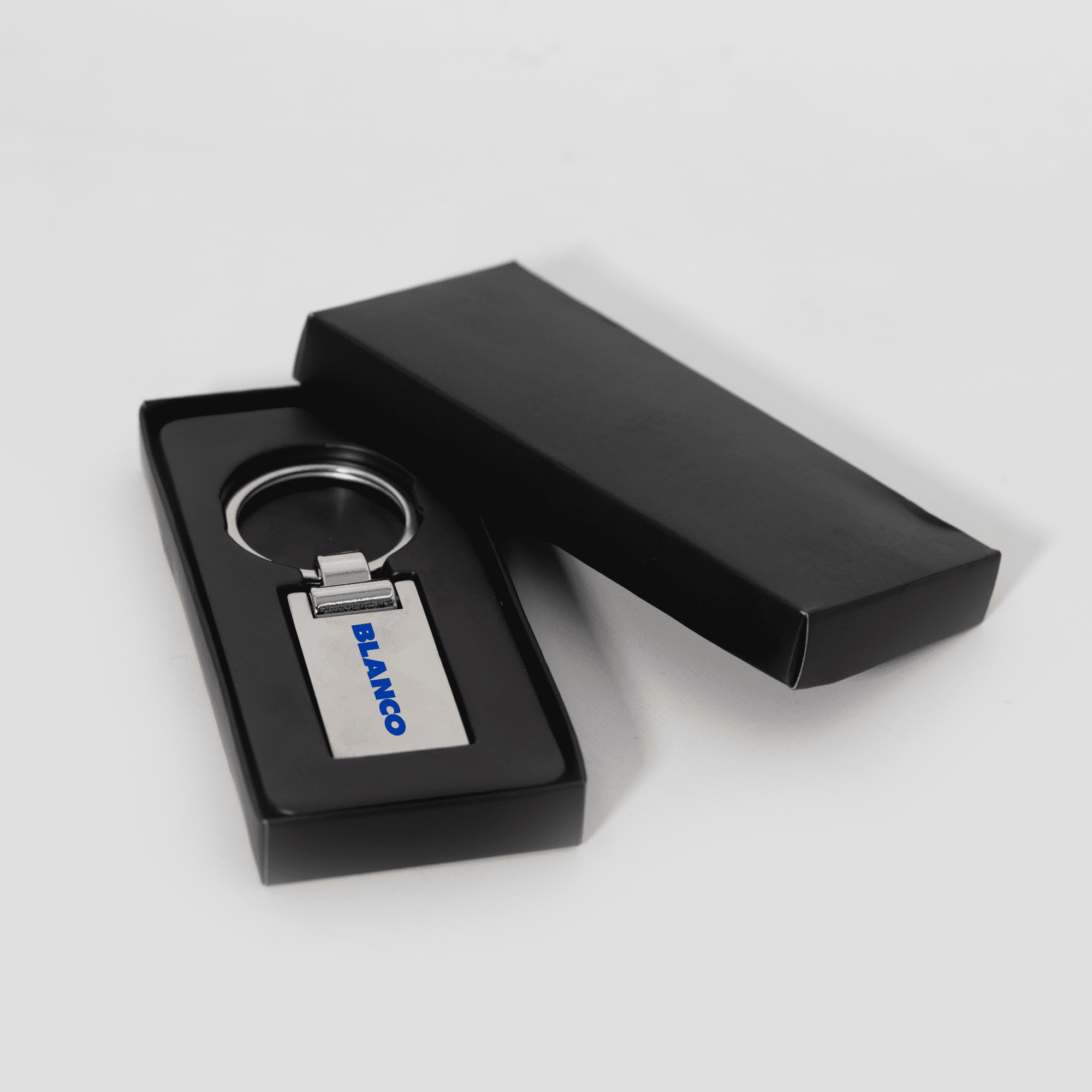 A silver keychain in a black presentation box, featuring a simple design and a logo. Euro Silver KeyChain - Image 1