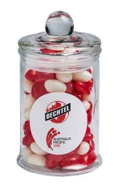 A small glass apothecary jar filled with red and white jelly beans, featuring a logo on the front. Small Apothecary Jar with Mini Jelly Beans 115g - Image 1