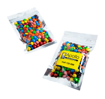 Silver zip lock bags containing colourful M&Ms, with one bag clearly visible and a logo present. Silver Zip Lock Bag with Mini M&Ms 50g - Image 1