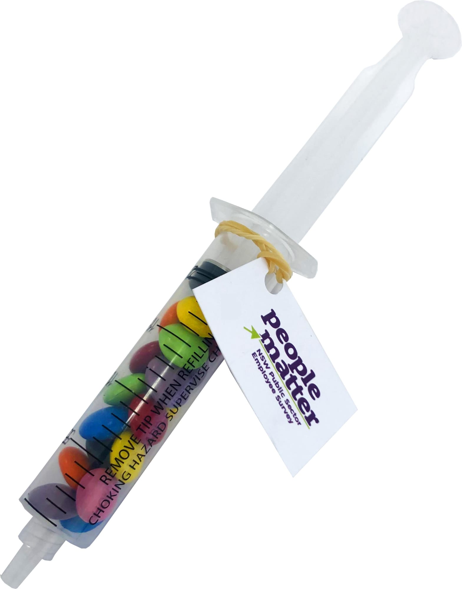 A syringe filled with colourful choc beans in various shades, featuring a tag and a logo. Syringe with Choc Beans 20g - Image 1