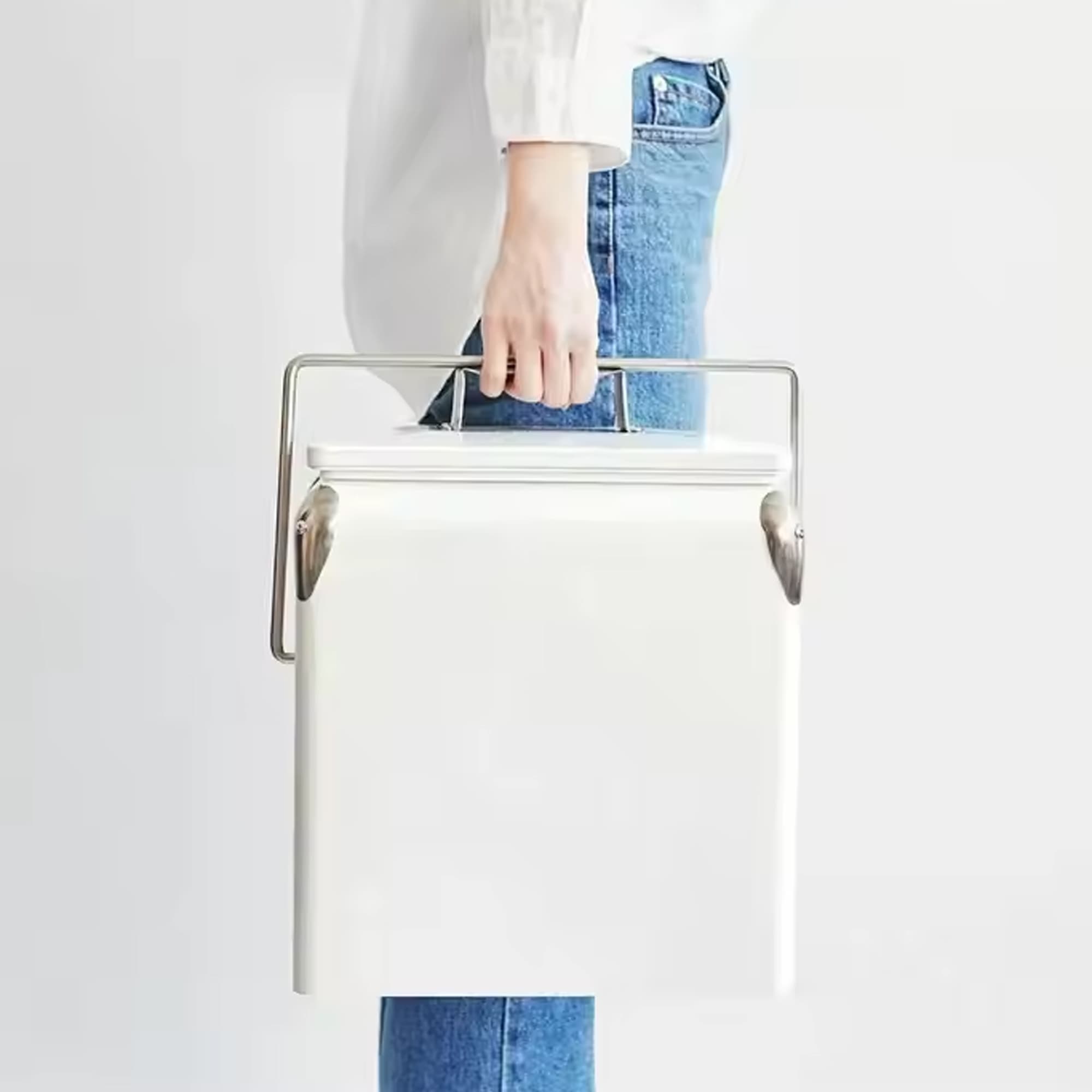A white metal ice cooler box with a silver handle being held by a person in blue jeans. It features a logo. Retro Metal Ice Cooler Box 13L - Image 1