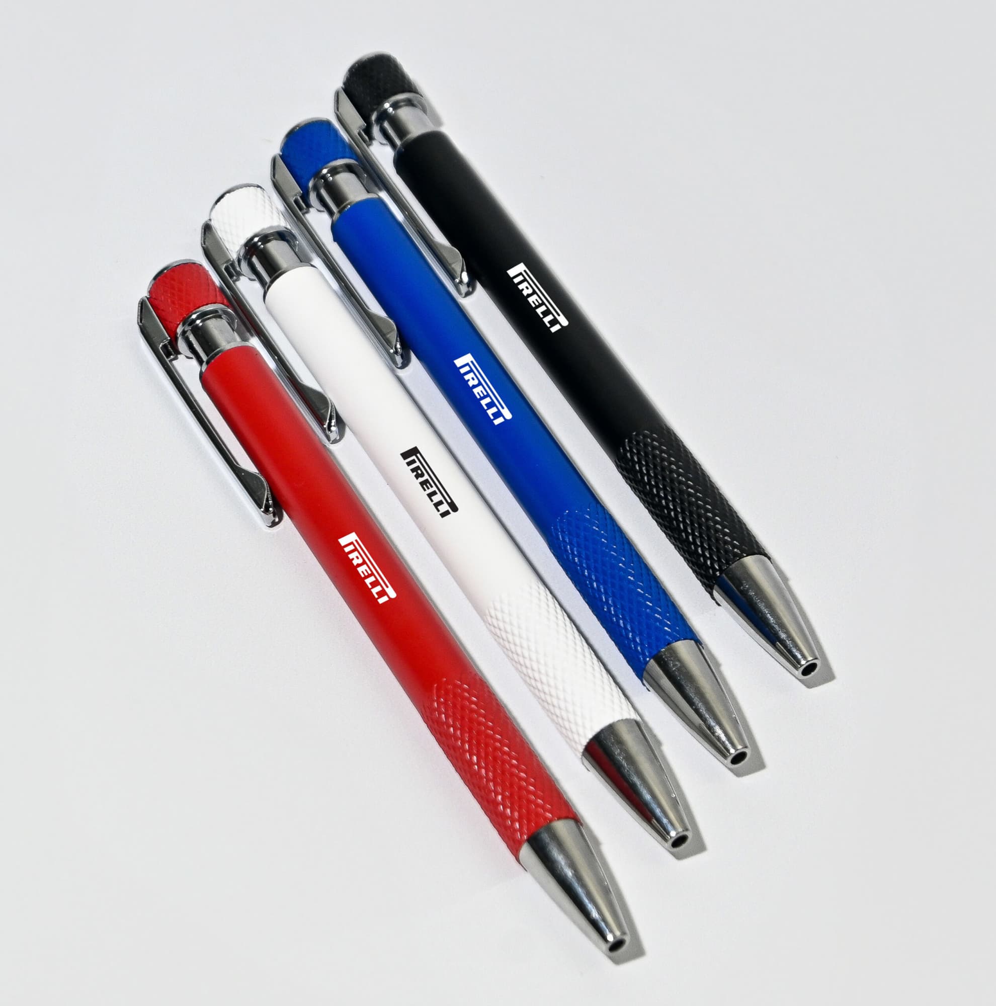 A collection of five ball pens in red, white, blue, black, and silver, featuring a textured grip and a logo. Stark Recycled Aluminum Ball Pen - Image 1