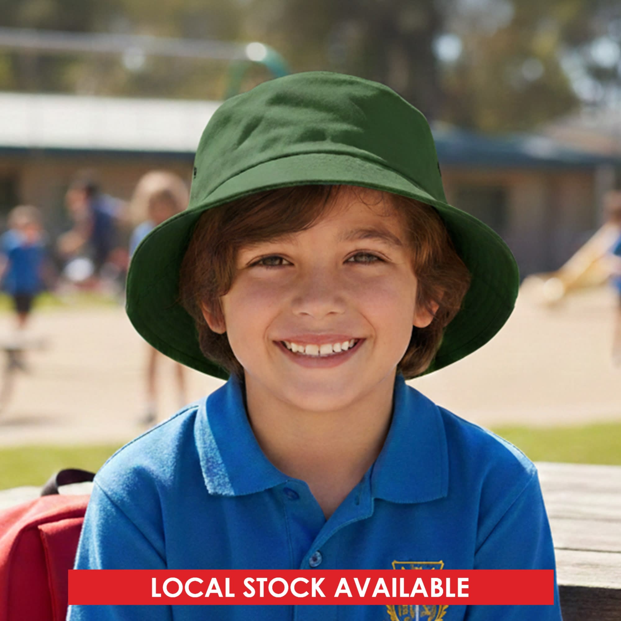 A green bucket hat on a smiling child, with a playground scene in the background. The hat has a logo. Long Beach Bucket Hat – Small - Image 1