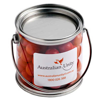 A small PVC bucket filled with orange choc drops, featuring a metal handle and a branding label. Small PVC Bucket with Orange Choc Drops 160g - Image 1