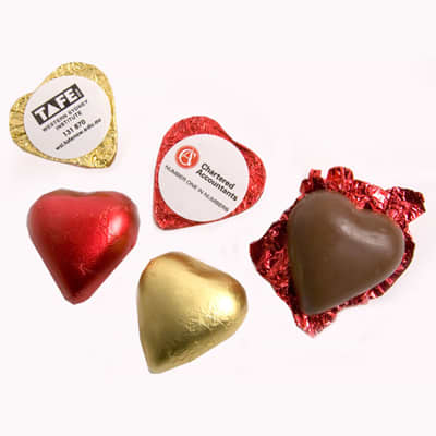 A selection of chocolate hearts in red, gold, and brown foil, featuring various shapes and wrapping. Chocolate Heart - Image 1