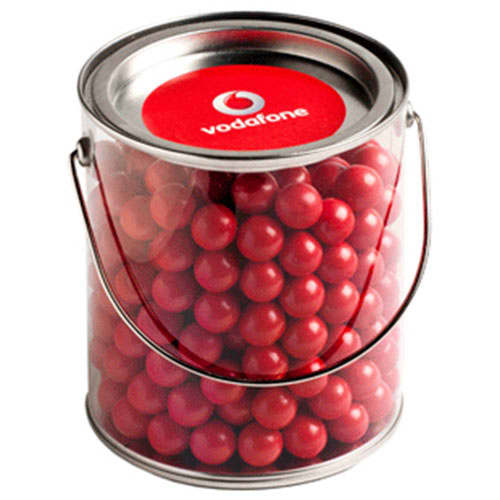 A clear bucket filled with vibrant red chocolate balls, featuring a lid and a metal handle. Big PVC Bucket with Orange Choc Drops 800g - Image 1