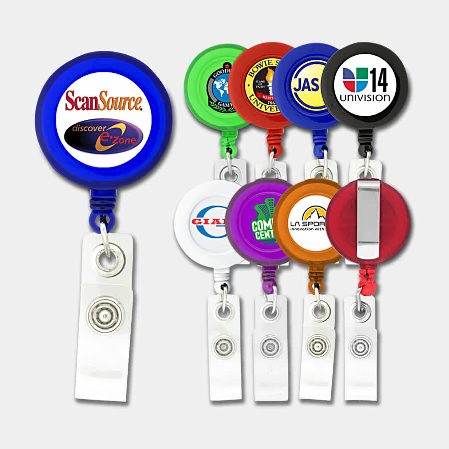A selection of round badge holders in various colours, each with a logo, attached to a retractable clip. Round Badge Holder - Image 1