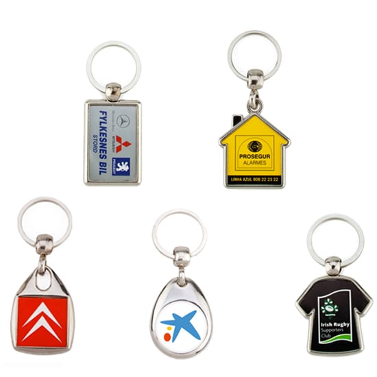 A collection of five metal key rings in various shapes and colours, each featuring a different logo or design. Metal key ring - bulk packed - Image 1