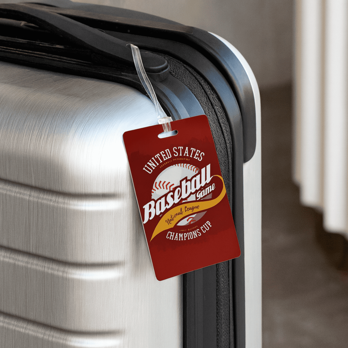 A red imprinted mini luggage tag is attached to a sleek, silver suitcase, featuring a logo and design. Imprinted Mini Luggage Tag - Image 1
