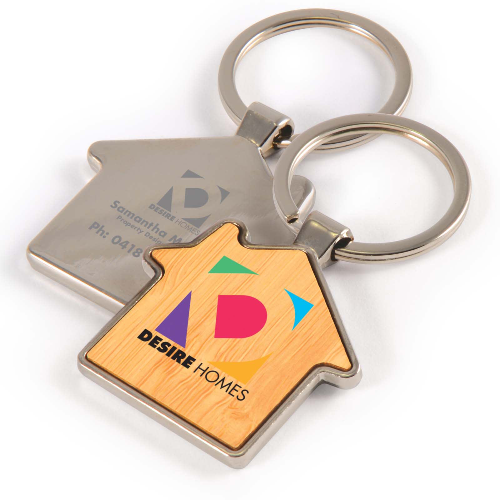 A house-shaped keytag with a bamboo and zinc design featuring a colorful logo and contact information. House Bamboo Zinc Keytag - Image 1