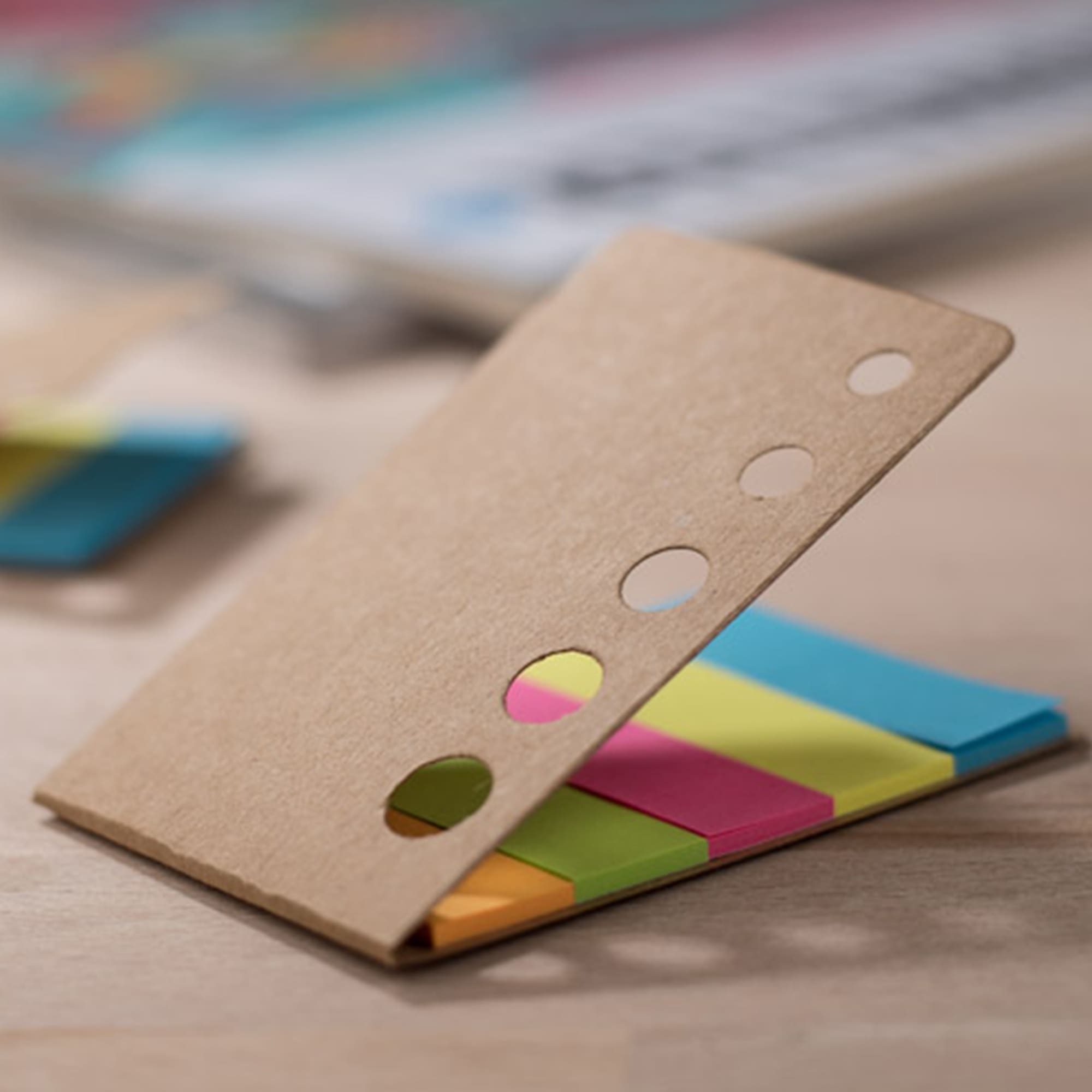 A set of sticky notes in bright colours, packaged in a brown cardboard holder with cut-out circles. Dotty Sticky Note - Image 1