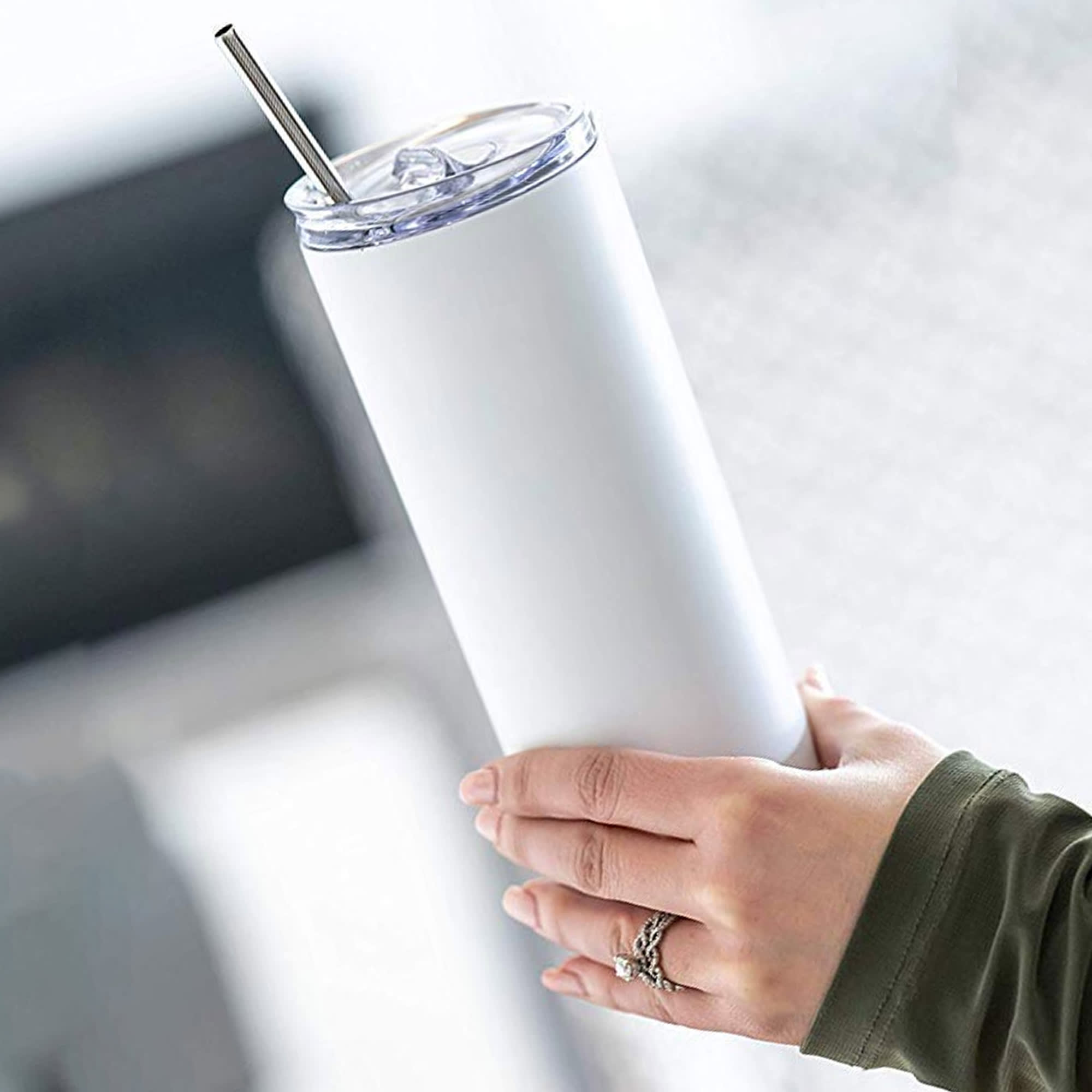 A white drink bottle with a clear lid and metal straw, held in a hand, featuring a sleek design. Vista Mug - Image 1