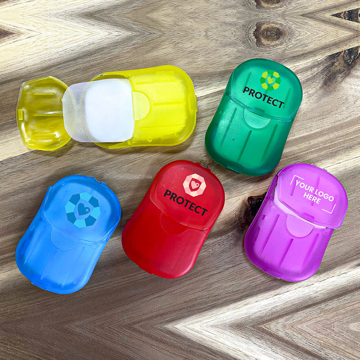 A collection of small, colourful containers in yellow, green, red, blue, and purple, featuring various logos and branding. Soapy - Image 1