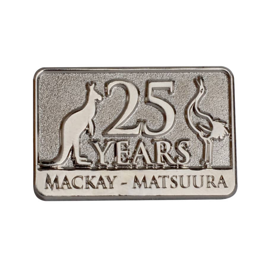 A metallic lapel pin featuring a kangaroo and an emu, with the text "25 YEARS MACKAY - MATSUURA." Die Struck Pins - Image 1