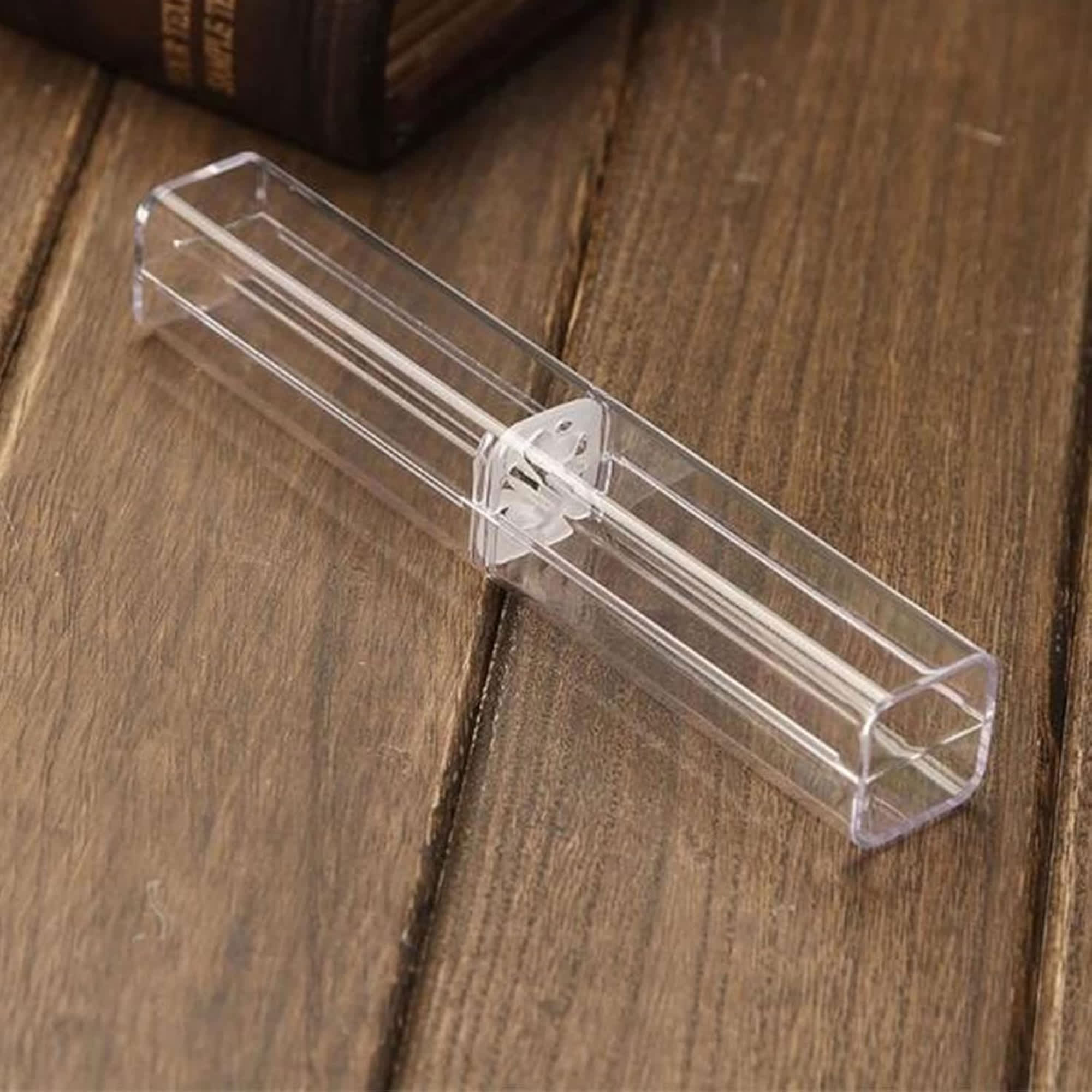 A transparent rectangular pen case with a clear lid, resting on a wooden surface. Case 360 Degree - Image 1