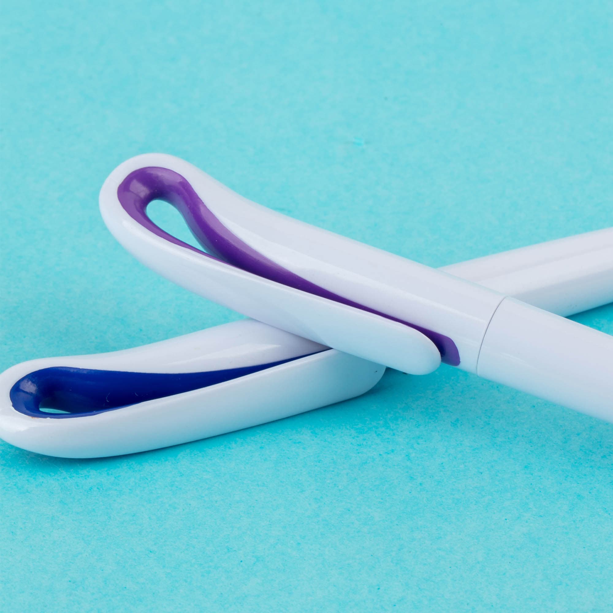 A pair of plastic pens in white with purple accents, featuring a distinctive design and a logo. Harvo - Image 1
