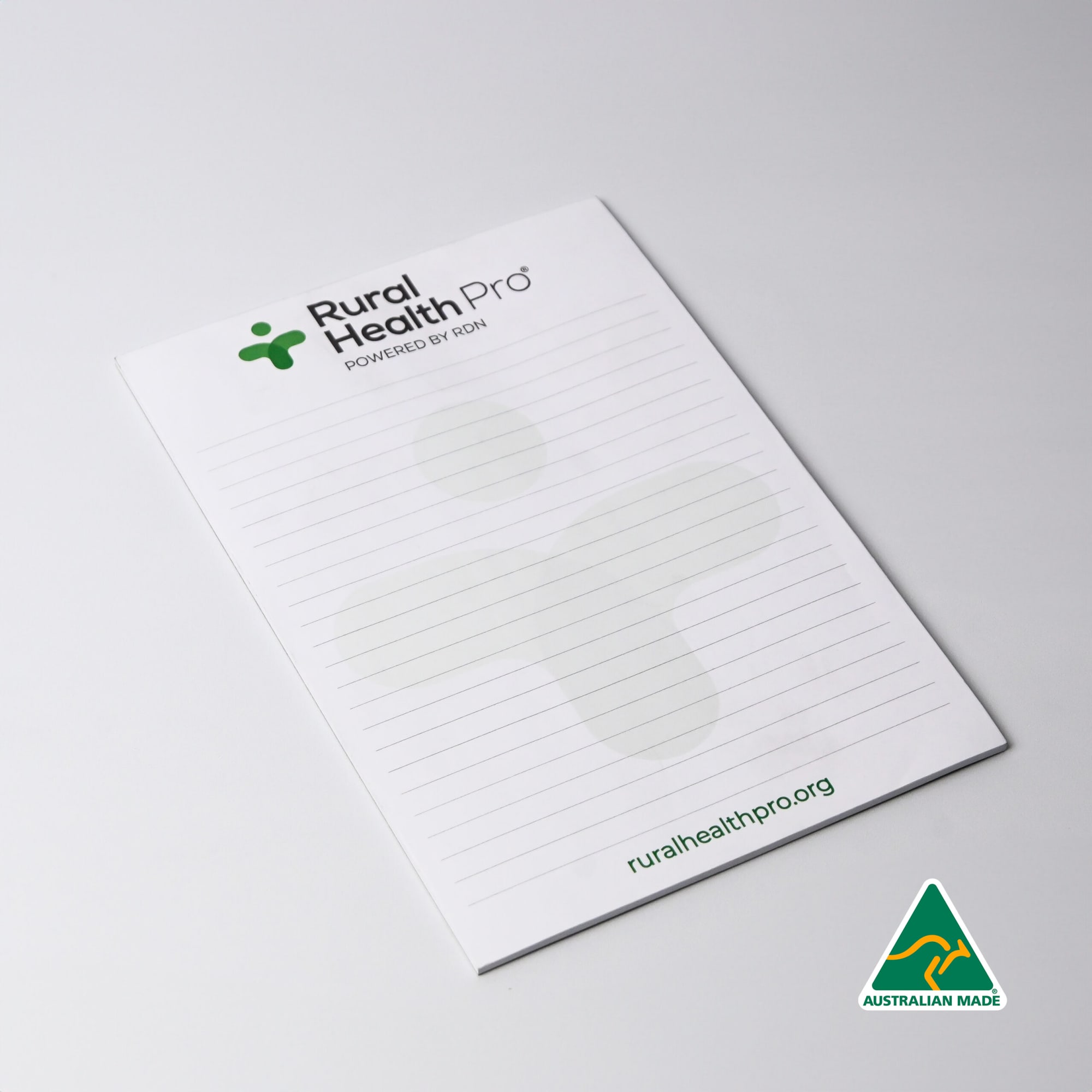 A5 notepad with 25 leaves, featuring a green logo, white background, and lined pages. Australian made. A5 Note pad (25 leaves per pad) - Image 1