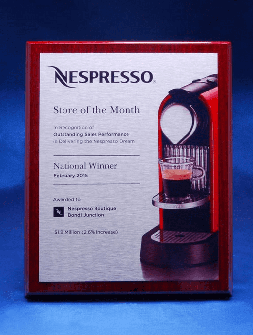 A printed plate mounted on a polished timber plaque featuring a coffee machine design and a logo. Printed Plate on Piano Finish Timber Plaque - Image 1