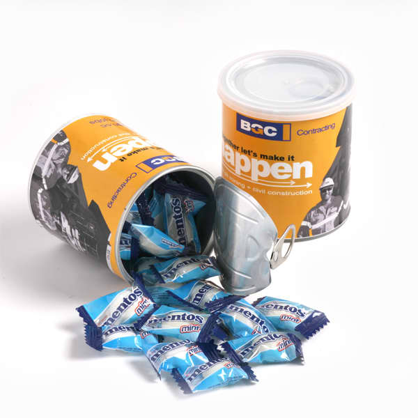 A cylindrical container in orange and white, filled with blue Mentos mints, with some mints spilling out. Pull Can with Mentos x33 100g - Image 1