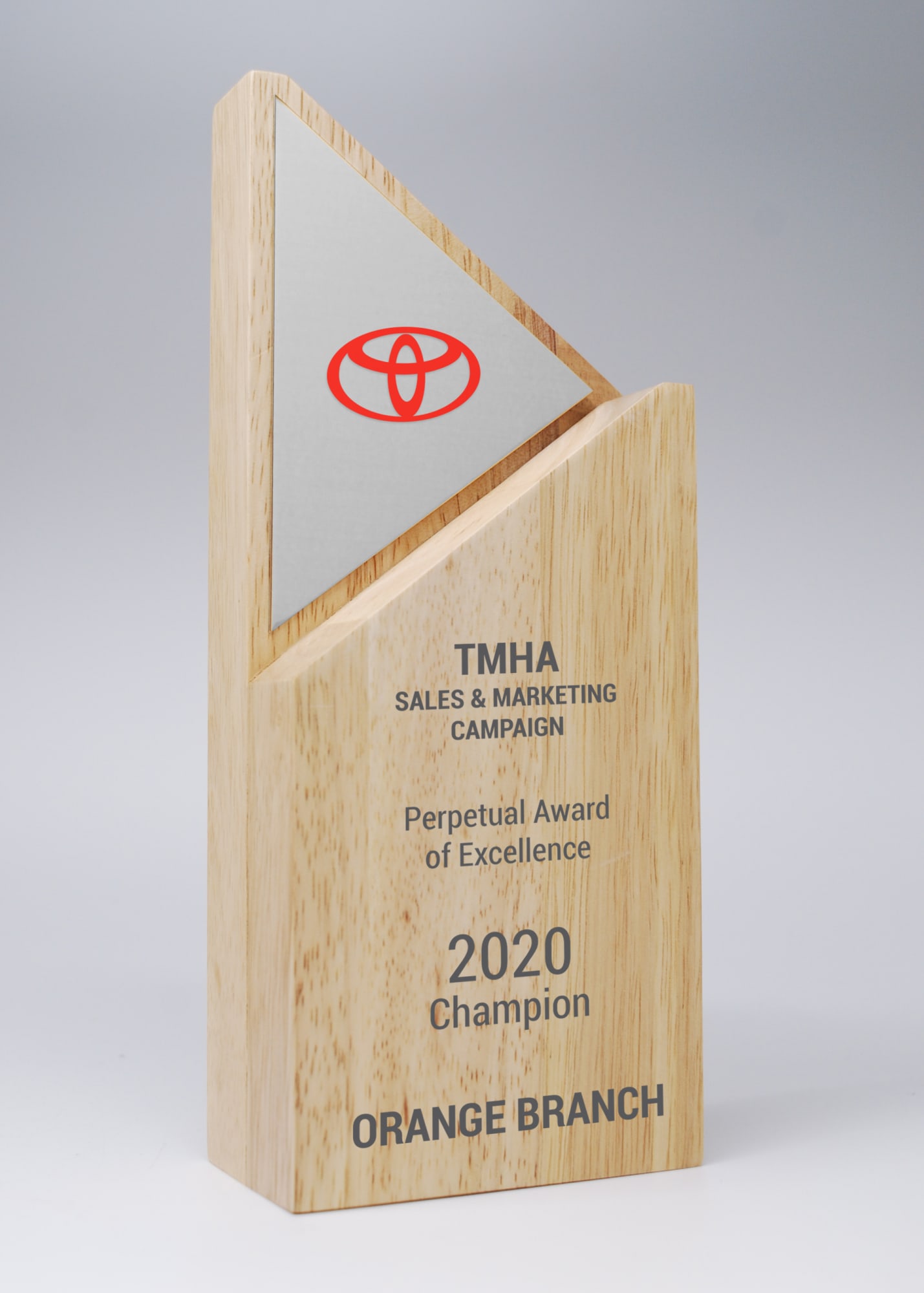 A wooden award with a triangular design and a silver printed plate, featuring a logo and engraved text. Arrow Wood Award with Mirror Silver Printed Plate - Image 1