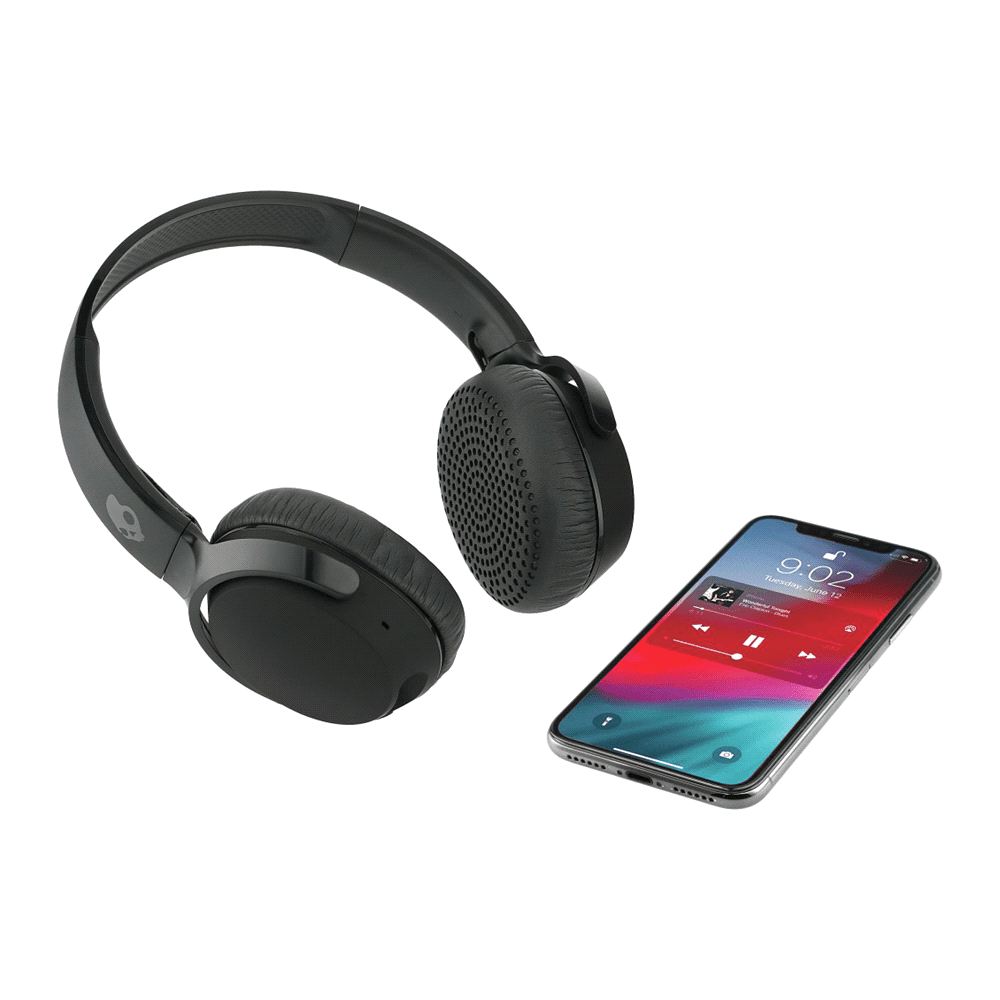 Wireless headphones in black beside a smartphone displaying a music player interface. Skullcandy Riff Wireless - Image 1