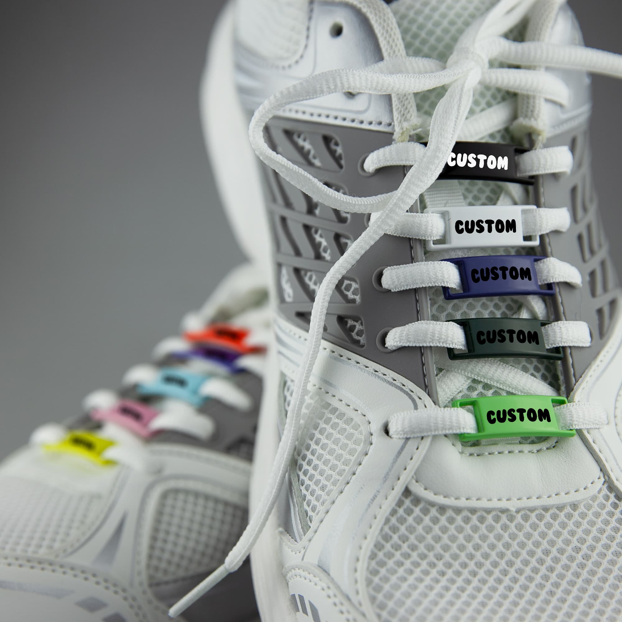 A pair of white sneakers featuring colourful luxury shoelace charms with a custom design. Classic Shoelace Charms - Image 1
