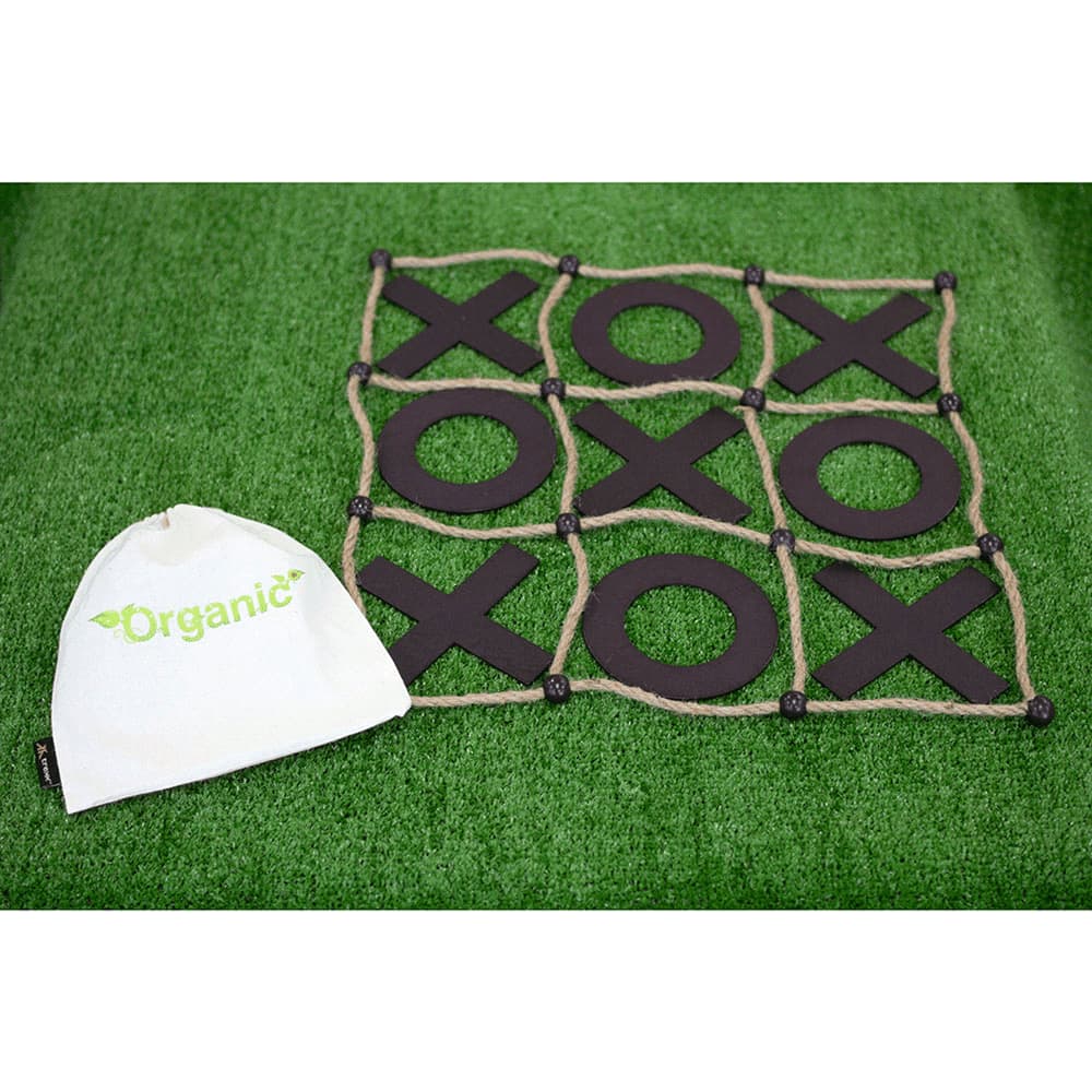 A Tic Tac Toe game with a black grid and wooden pieces, accompanied by a small white, branded bag, set on green grass. Trekk Tic Tac Toe Game - Image 1