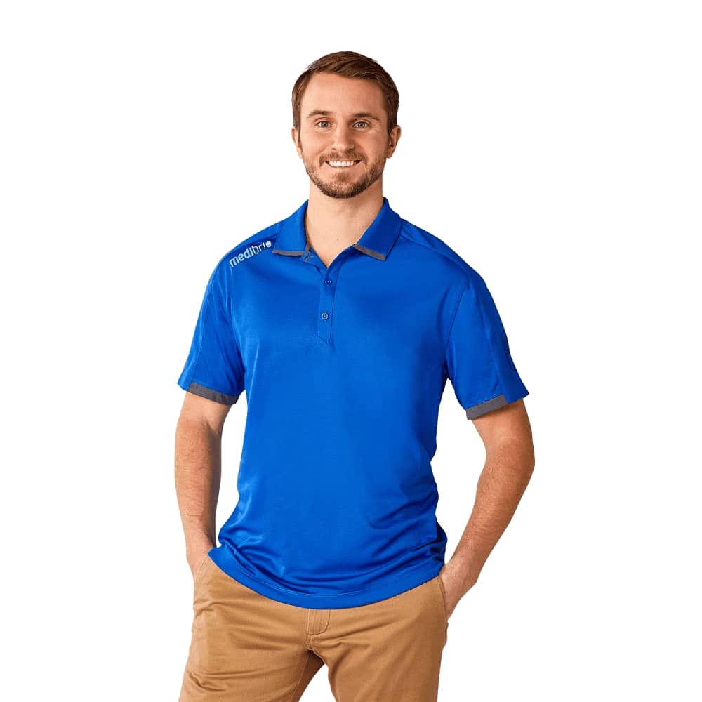 A blue men's short sleeve performance polo shirt with a logo on the chest, modelled by a man. Men's Cerrado Short Sleeve Performance Polo - Image 1
