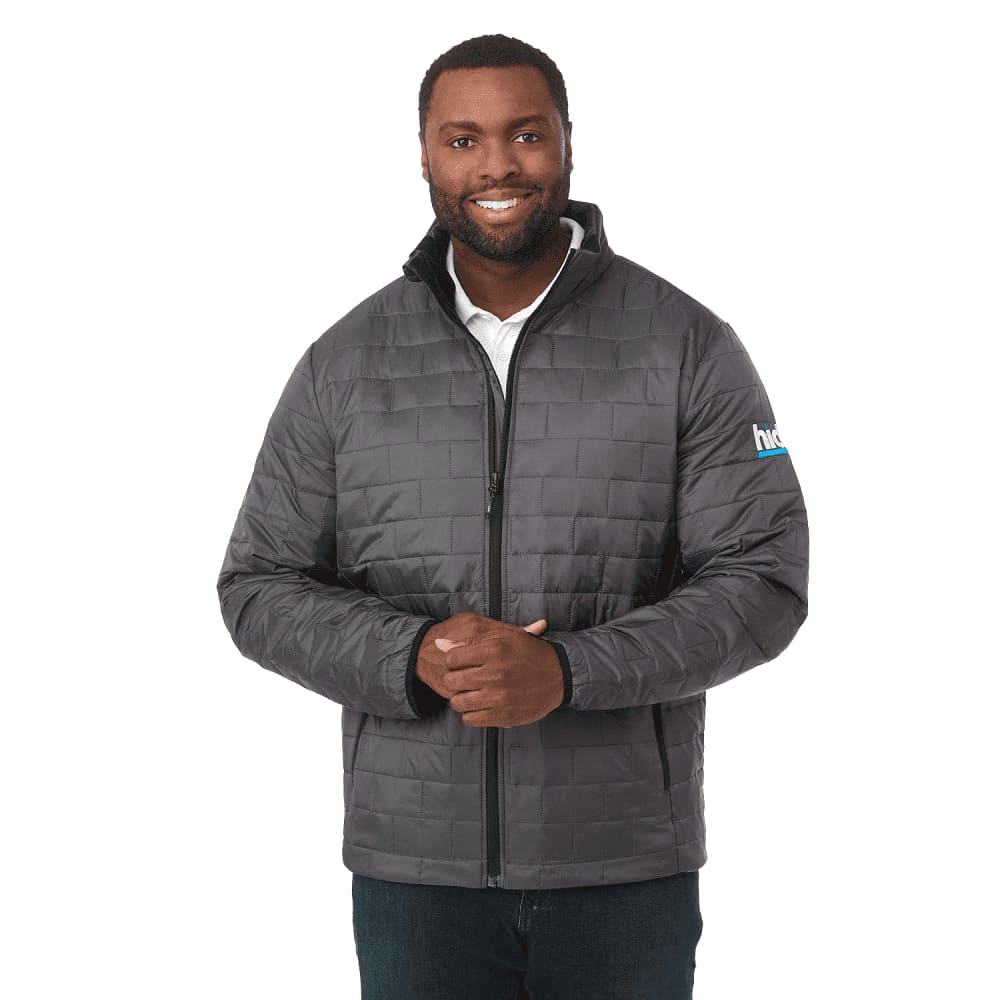 A man wearing a grey puffer jacket with a zip front and a logo on the sleeve. Men's Telluride Lightweight Packable Insulated Puffer Jacket - Image 1
