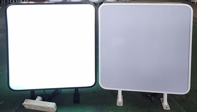 Two wall mount light boxes, one with a black frame and illuminated, the other with a white frame and unlit. Wall Mount Light Box - Image 1