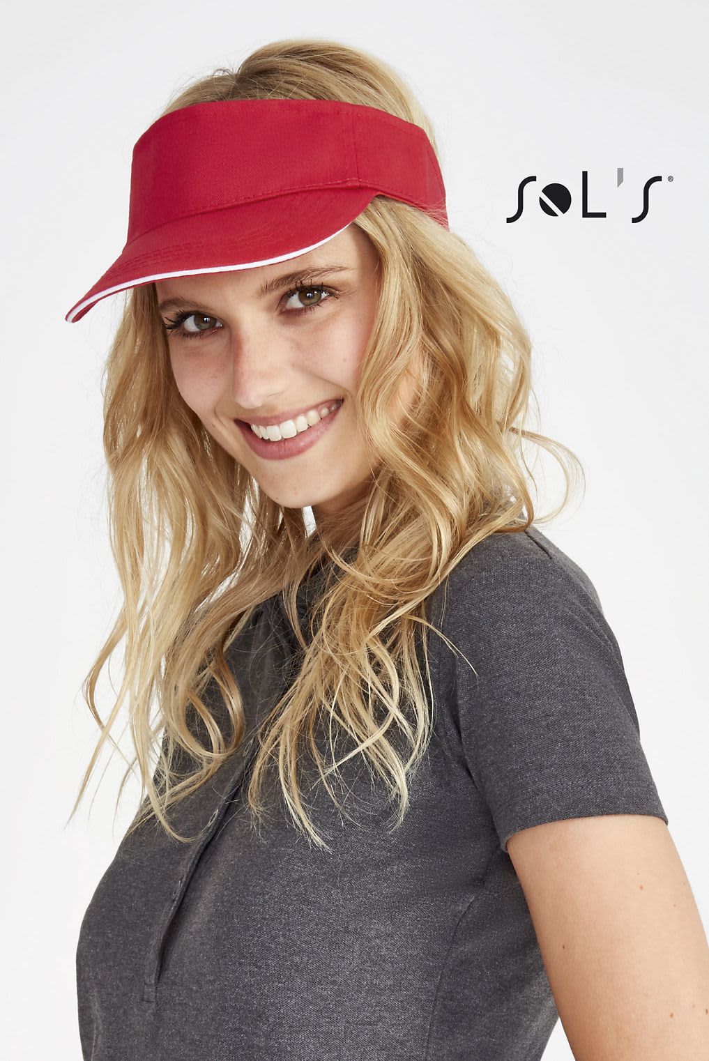 A red visor with a white trim worn by a smiling woman, featuring a logo on the side. VISOR 150gsm 100% cotton ACE - Image 1