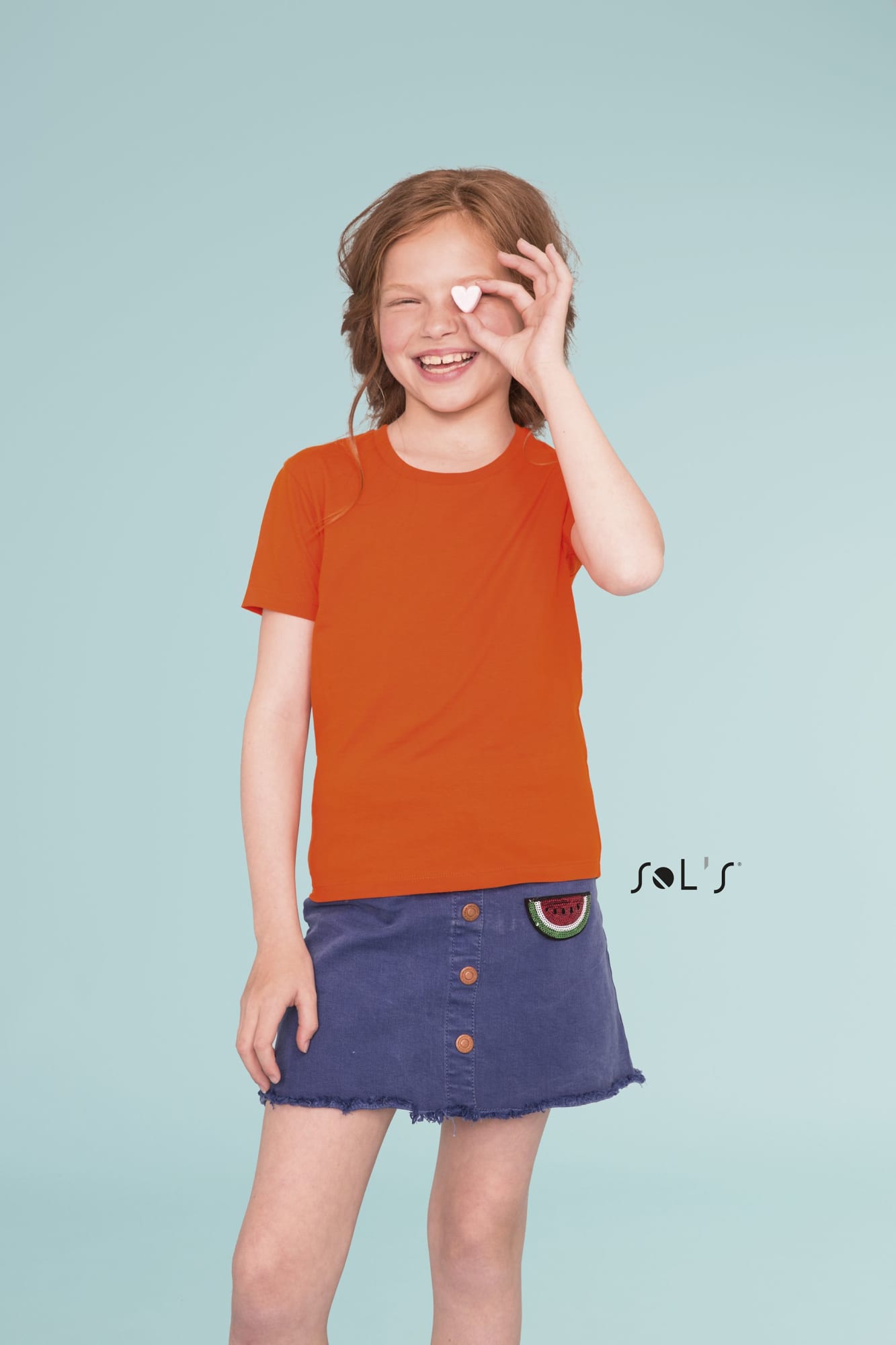 An orange round neck T-shirt made from 100% organically grown cotton, worn by a smiling child. Features a logo. T shirt KIDS ROUND NECK 100% Organically grown cotton Milo - Image 1