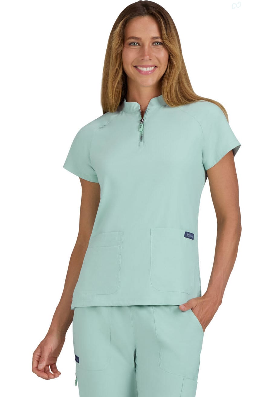 A limited edition scrub top in a soft mint green colour, featuring a zip neckline and two front pockets. Rena Top (Limited Edition) - Image 1