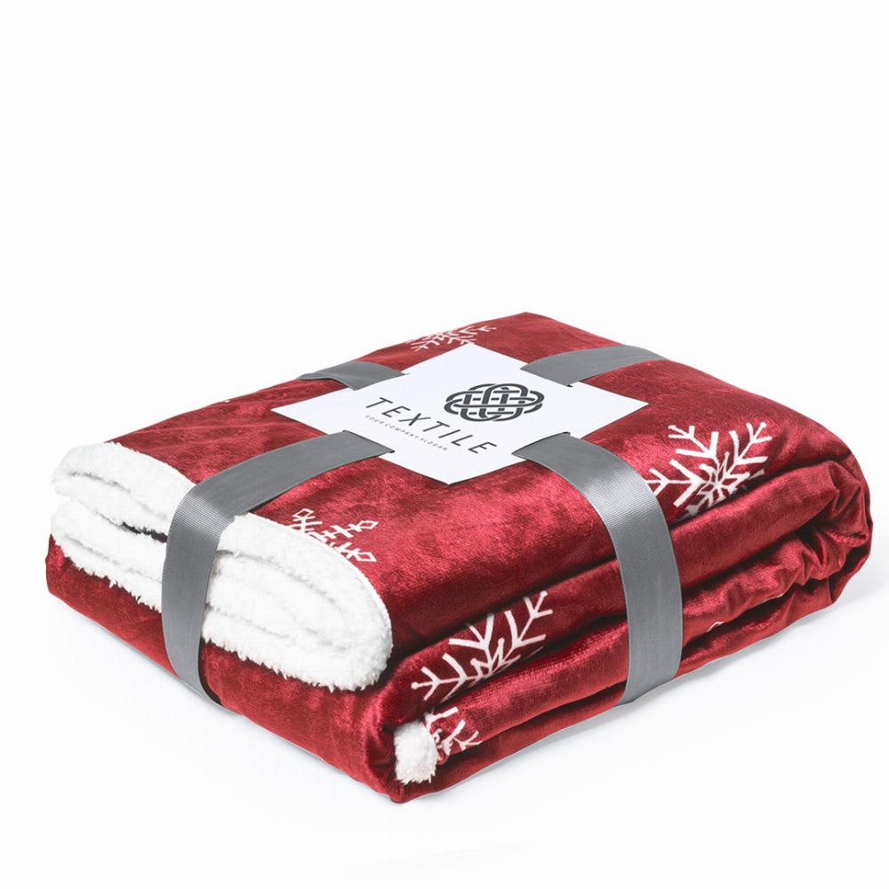 A red blanket featuring white snowflake patterns, neatly folded and secured with a grey band. It has a branded tag. Ricord - Image 1