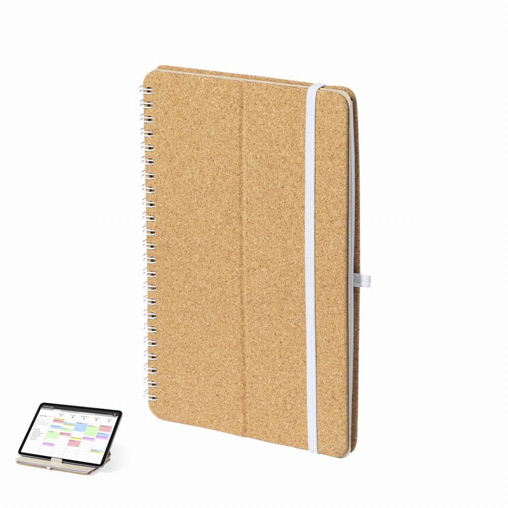 A cork-covered spiral notebook with a white elastic band, positioned next to a tablet. Fromky - Image 1