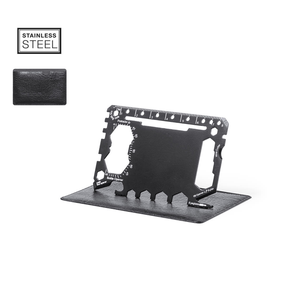 A black stainless steel multitool card displayed on a grey surface, featuring various tools and measurements. Frest Multitool - Image 1