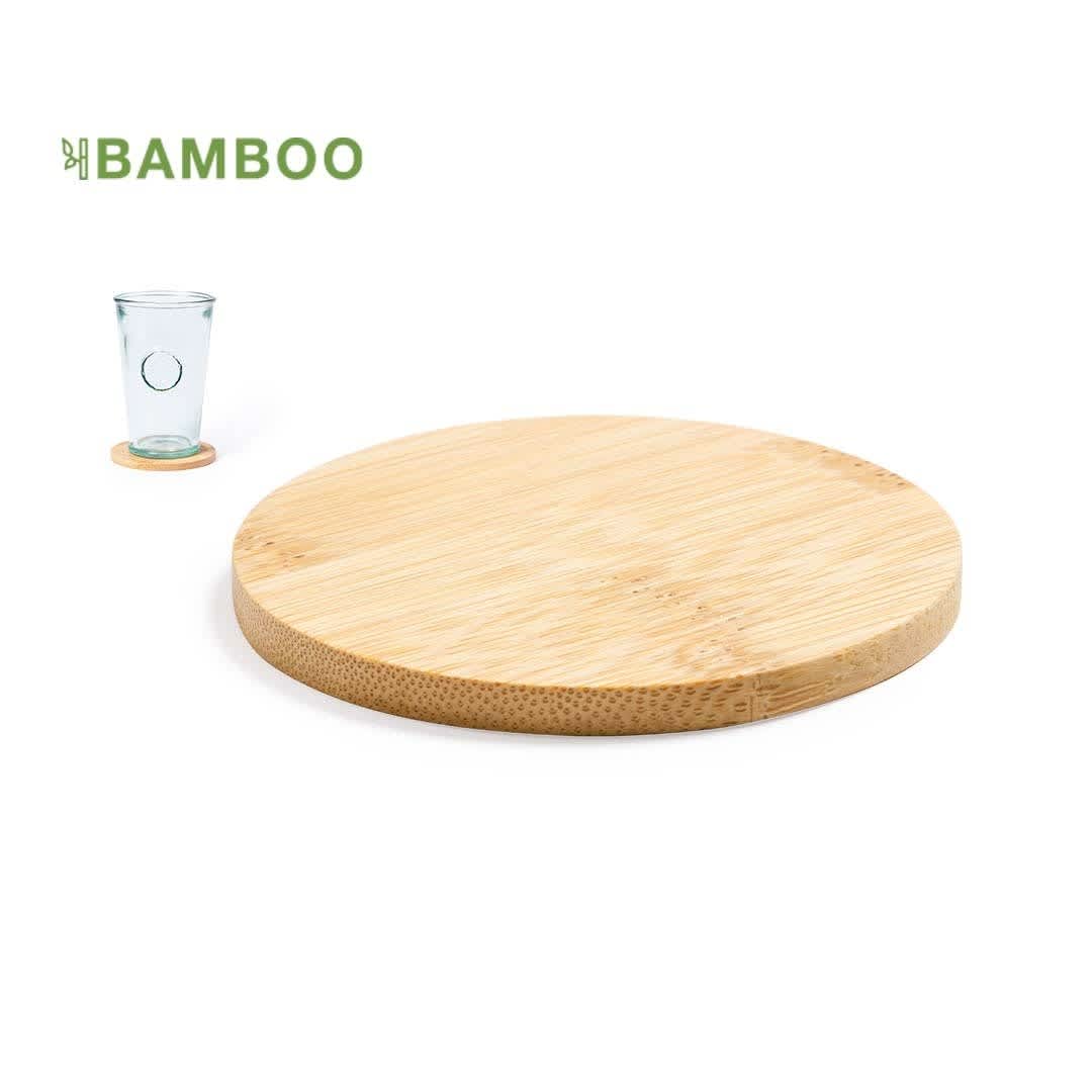 A round bamboo coaster with a smooth finish next to a clear glass. The coaster features a natural wood grain. Derrik Coaster - Image 1