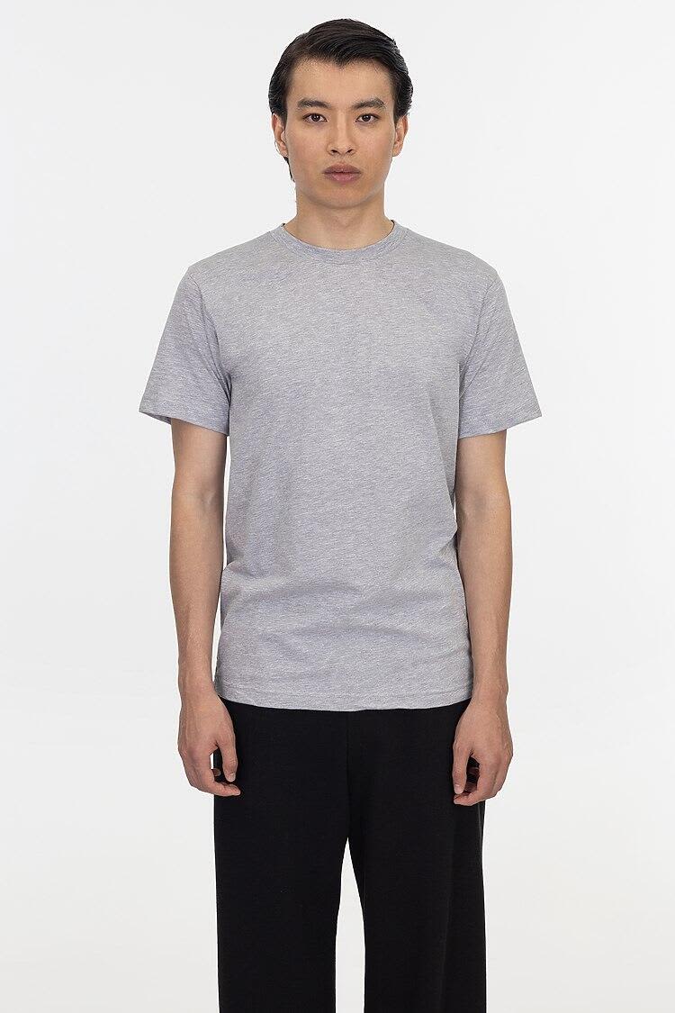 A grey short sleeve fine jersey crew tee displayed on a model, featuring a simple design and a logo. Short Sleeve Fine Jersey Crew Tee - Image 1