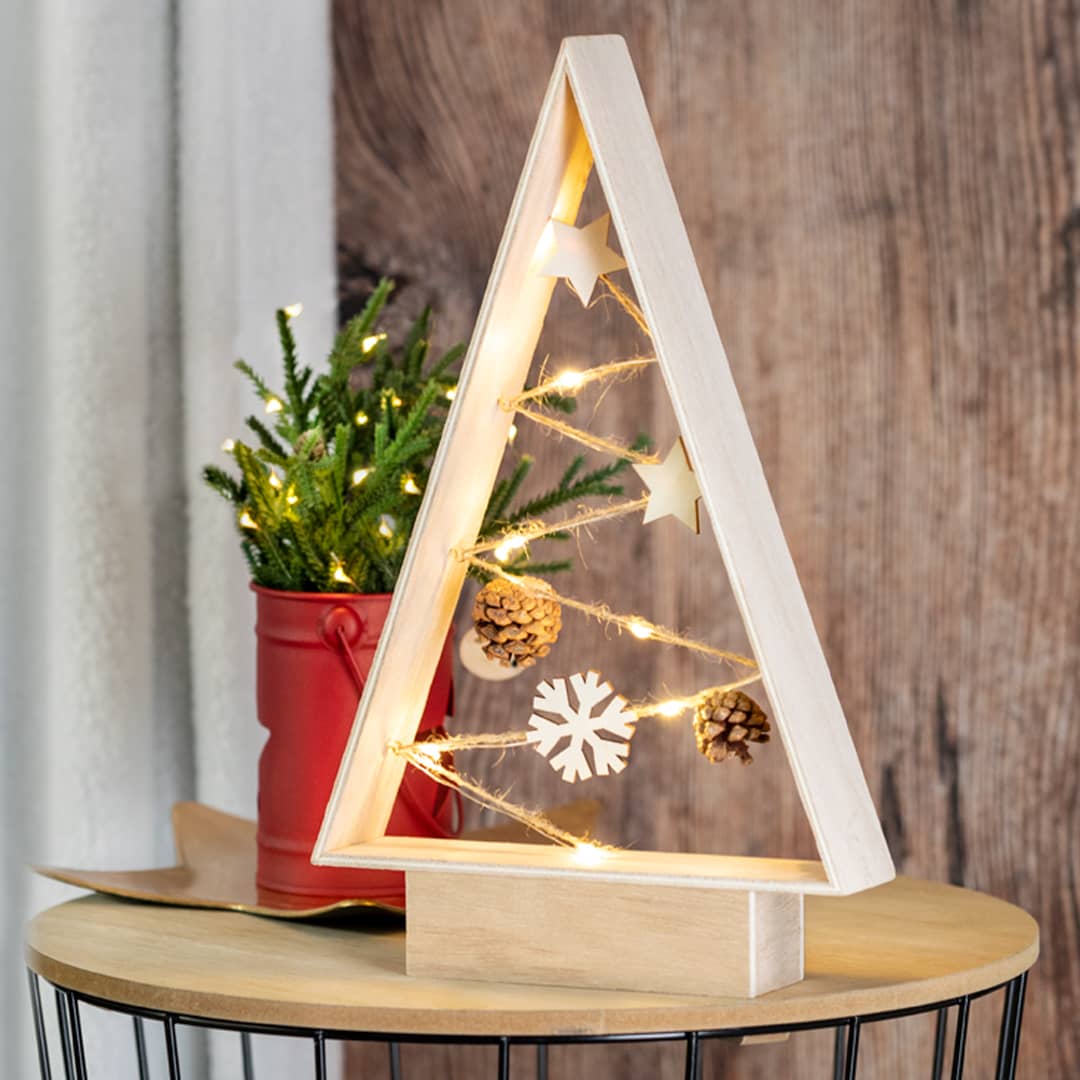 A wooden triangular Christmas tree with fairy lights, decorated with stars and pine cones, beside a red pot plant. Allurex - Image 1